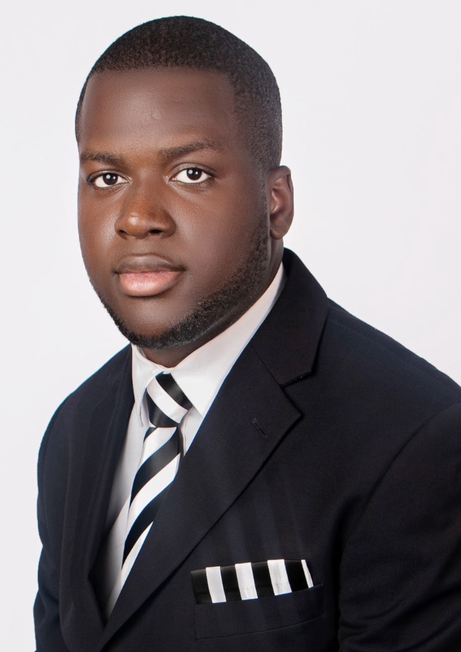 Kesiena Igho Oghoghorie in a black suit and striped tie