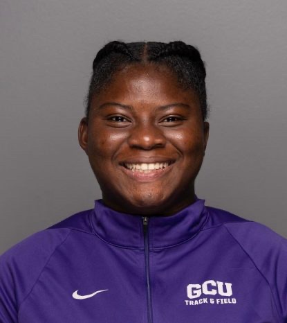 Onome Ogbeni smiling in a purple track and field jacket